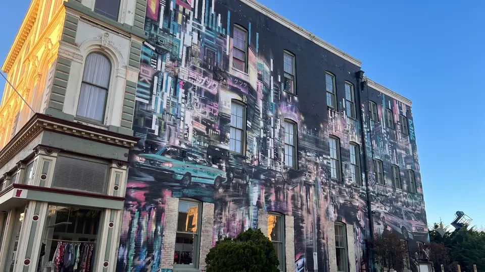Victorian building wrapped in a glitched neon cityscape mural, Old Town Eureka